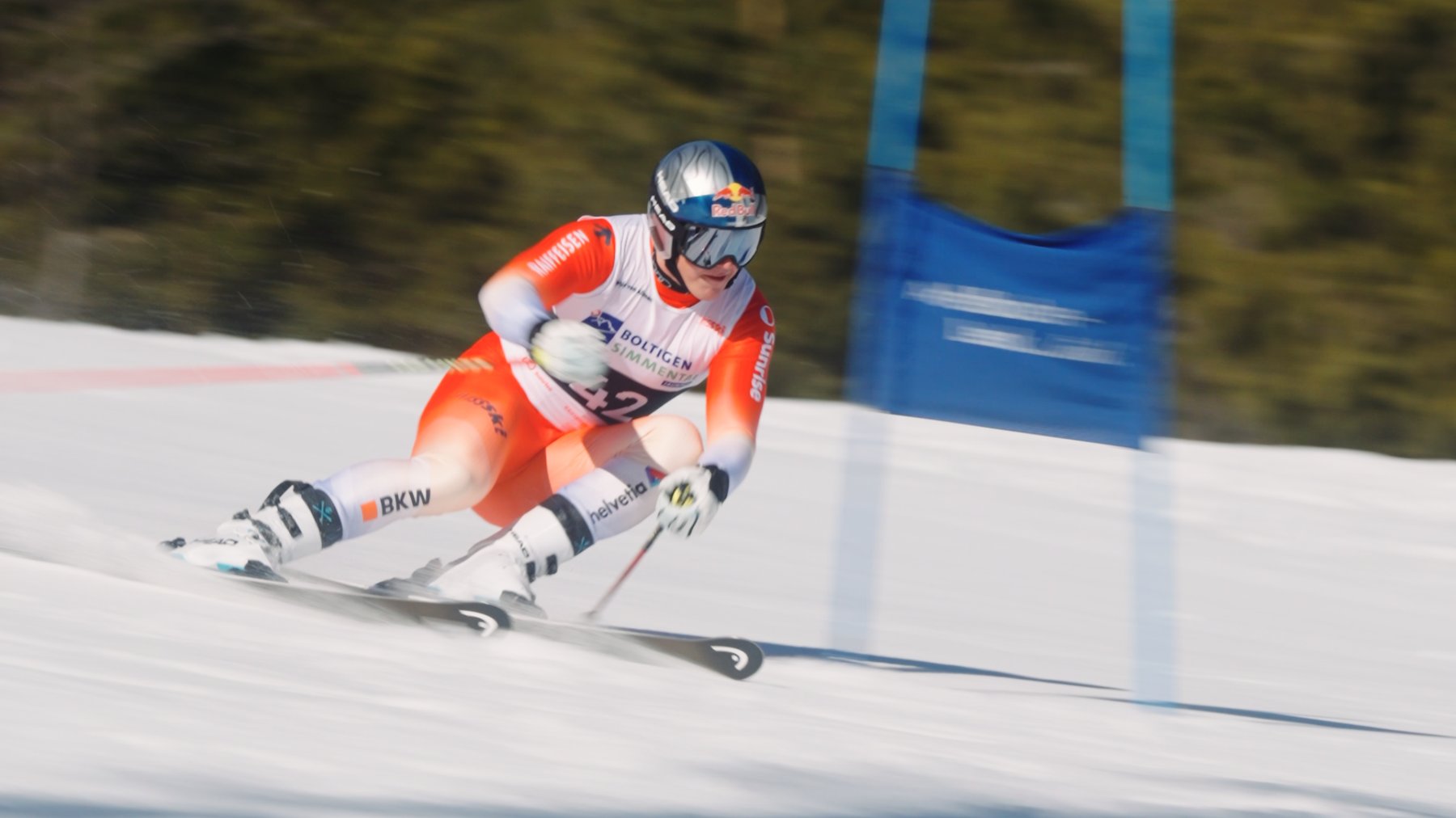 Franjo von Allmen fährt komplett sichtbar Ski-Rennen an einem Torlauf-Tor vorbei, Red-Bull-Logo auf dem Helm