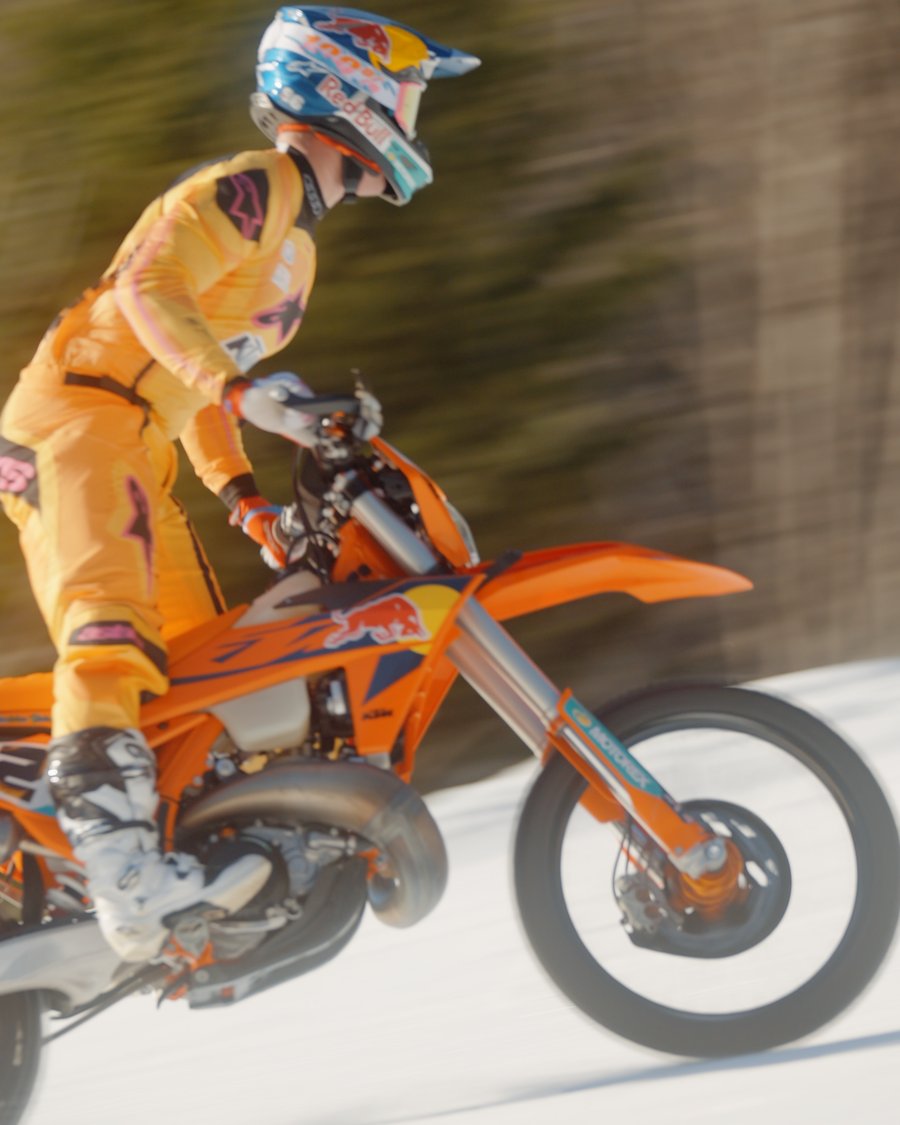Fahrer im gelben Outfit macht mit der KTM einen Sprung, Bewegungsunschärfe im Hintergrund