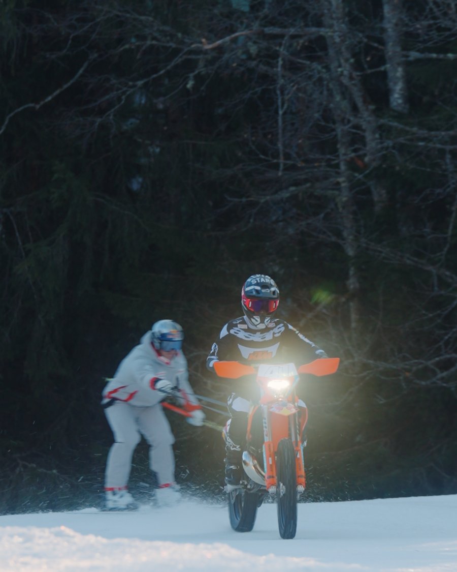 Nächtliche Aufnahme: ein Skifahrer lässt sich von einer KTM durch den Wald ziehen