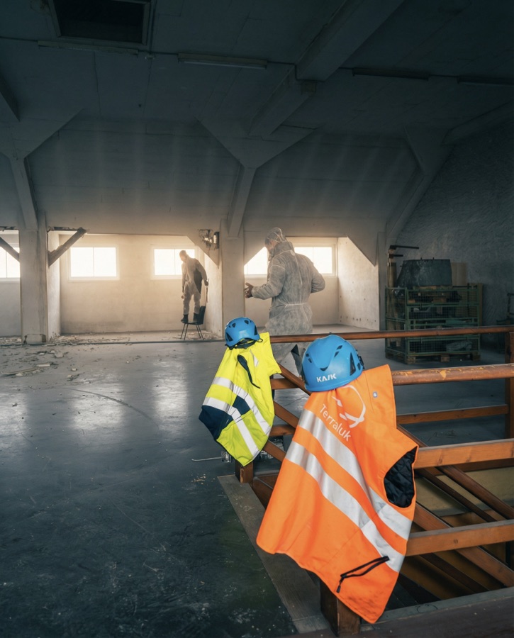 Helme und Warnwesten an einem Geländer auf der Baustelle