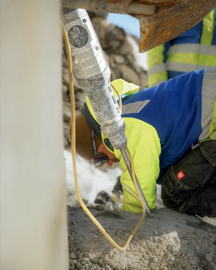 Mitarbeiter bohrt mit einem Presslufthammer in Beton
