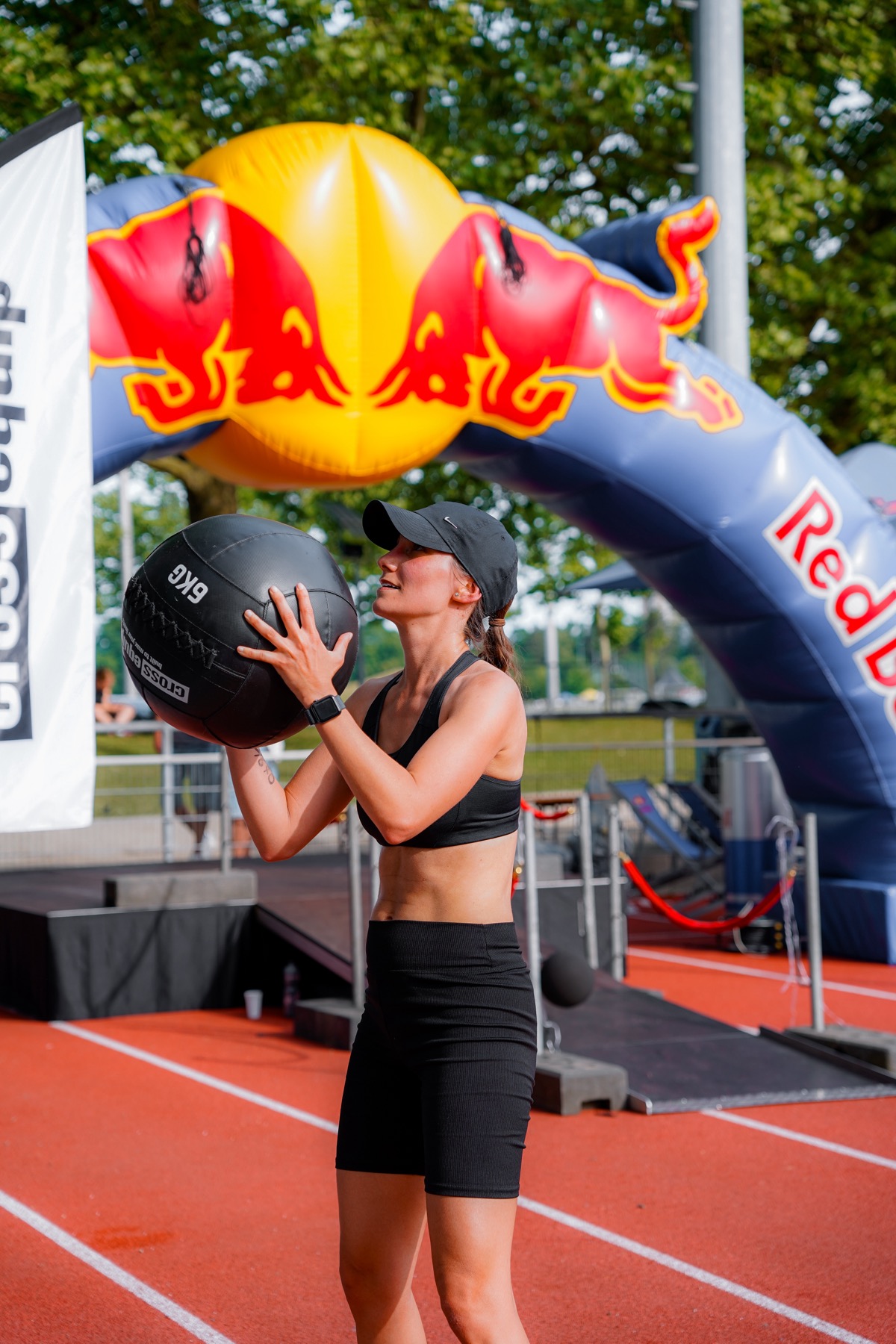 Athletin wirft einen Wall Ball vor dem Red-Bull-Bogen