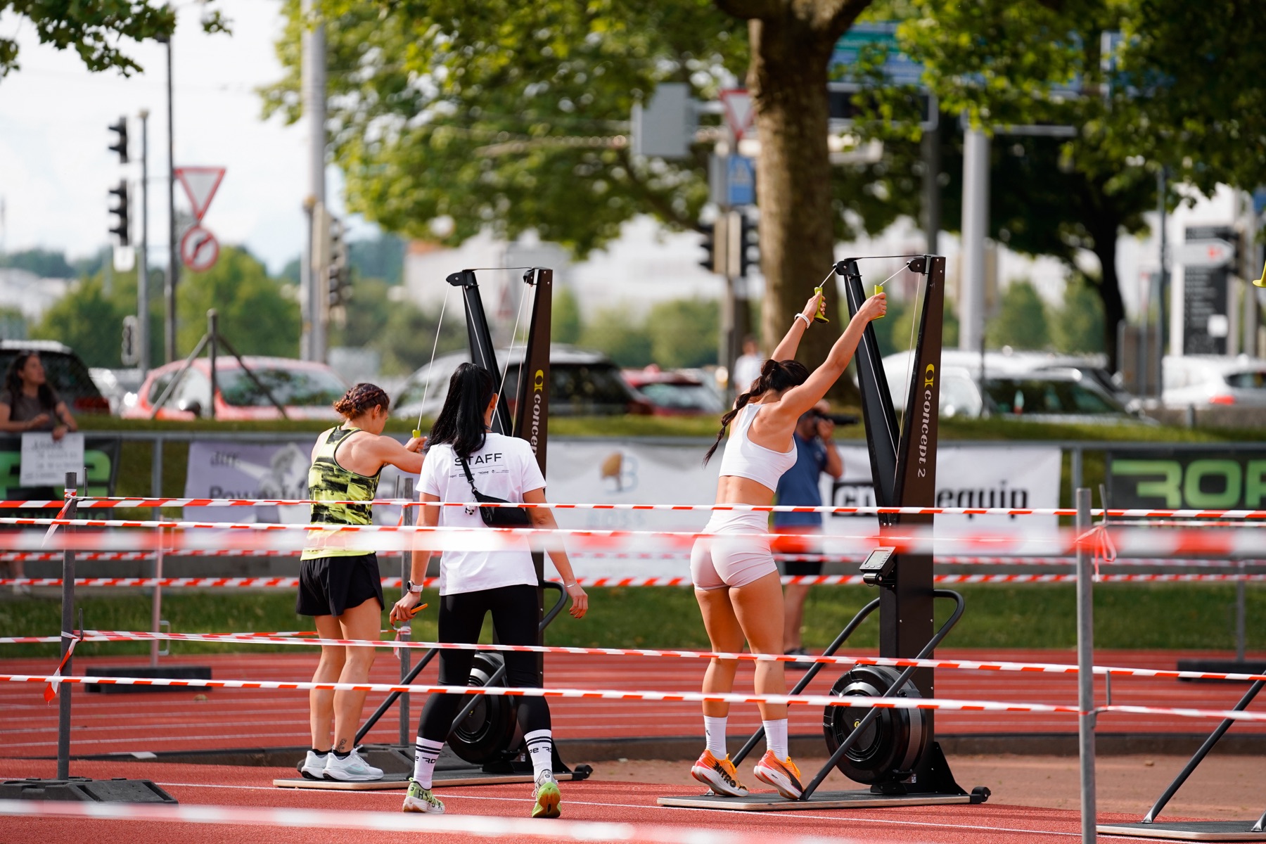 Athletinnen trainieren am Kabelzug entlang der Strasse
