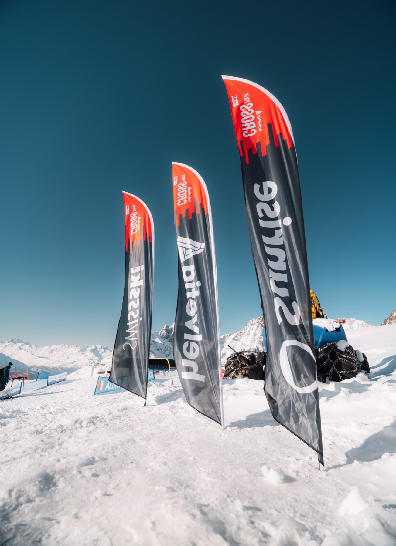 SWISS-, Raiffeisen- und Sunrise-Flaggen auf dem Bergrücken über St. Moritz